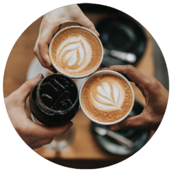 Three people toast with mugs of coffee.